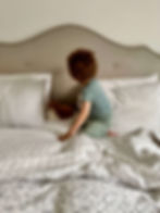 toddler playing in parents bed
