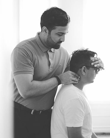 In a bright room, a skilled therapist from GTA Spine expertly massages another person's neck.