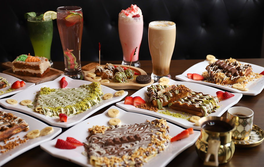 Assorted dessert crepes, waffles, and colorful beverages.