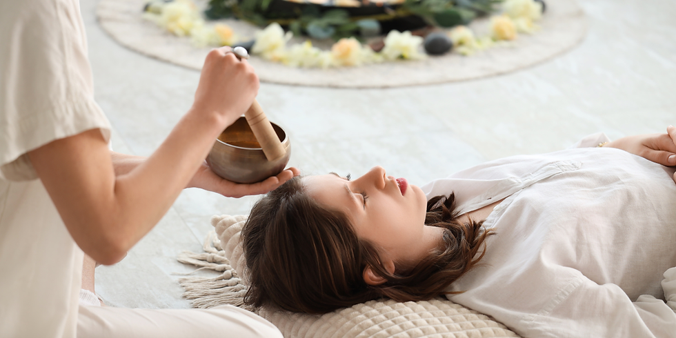 Aura cleansing therapy with sound bowl - energy healer restoring balance and calm for the person lying down.