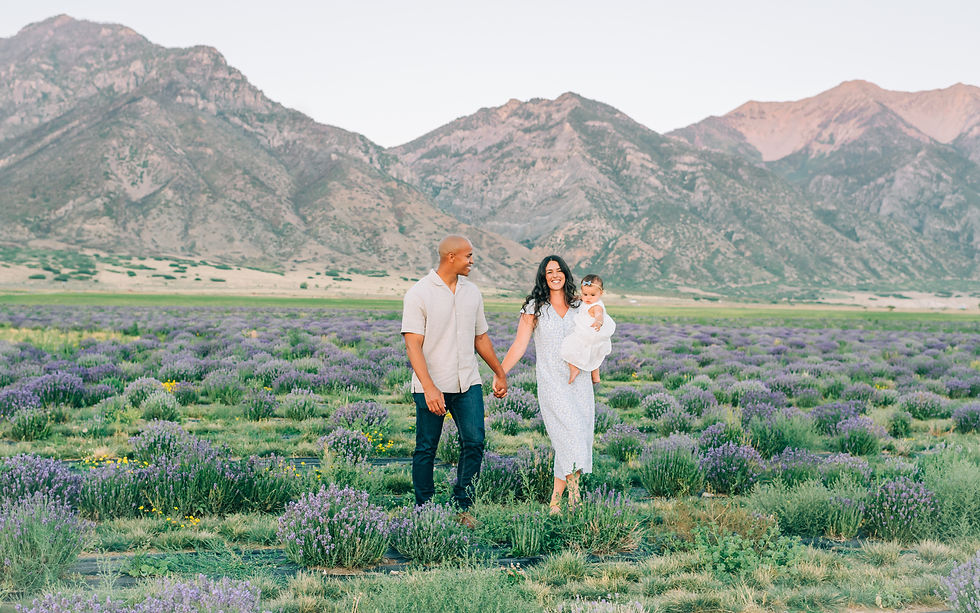 Family walking through lavender fields in the summer during a photoshoot with a Cache Valley photogr