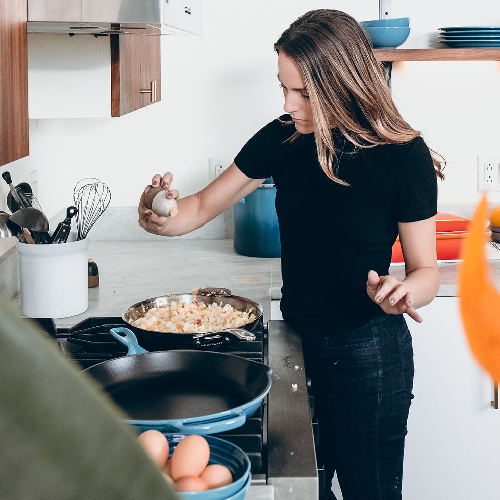 Mulher com ovo na mão cozinhando