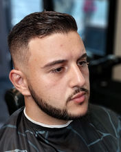 Front angle of a men’s textured crop haircut with a low fade, clean beard line up, and blended barber detailing for a modern professional hairstyle.