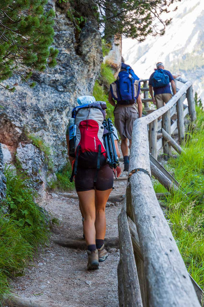 Alta Via 1 self guided hike in the Dolomites – hiker on AV1 trek with Dolomites hut booking along the trail.