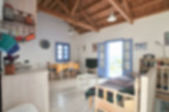 Open plan living room with wooden open to rafters ceiling and wooden floor.