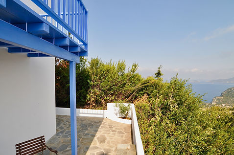 Below blue wooden balcony with sea views in Greece.