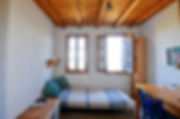 Guest bed with two windows behind