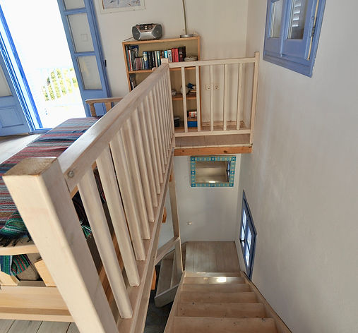 Wooden stairwell leading to lower floor of beach house, Greece.