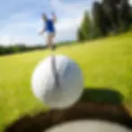A golfer celebrating as the golf ball drops into the cup