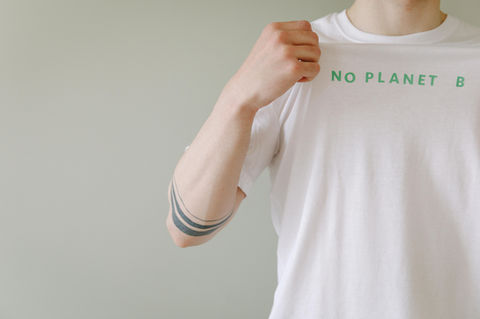 A man wearing a t-shirt made from organic cotton with a slogan No Planet B printed with sustainable dye made from algae