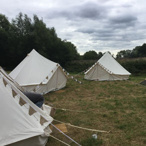 Exterior of 3 bell tents with bunting