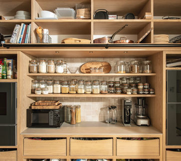 Walk in larder in oak with a mix of open shelving and drawers;  home to the Gaggenau ovens and a workspace.