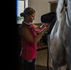 Rider putting saddle on a horse