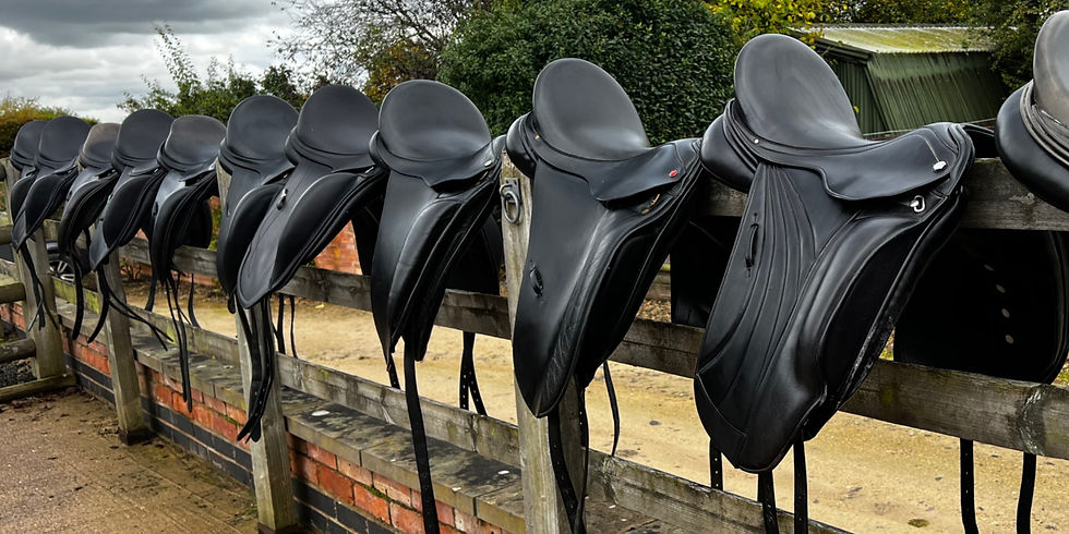 Eye-level view of a brown leather saddle resting on a wooden fence
