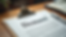 Eye-level view of a typed demand letter on a wooden desk with a pen beside it