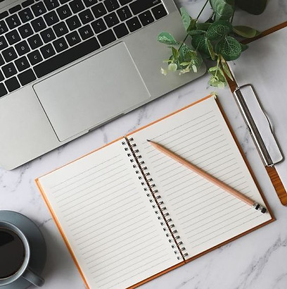 mesa de escritorio com notebook e caderno