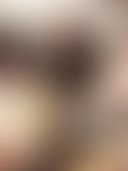 Three people playing a tabletop game, laughing around a table with maps, dice, and character sheets in a cozy room.