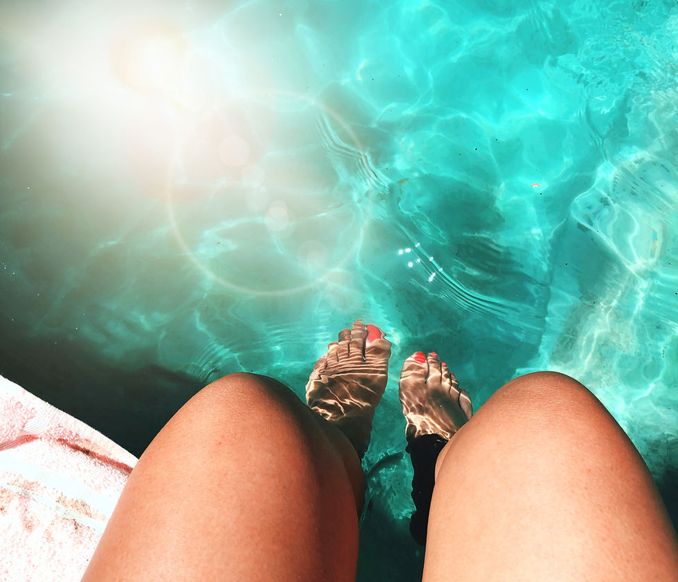 fille les pieds dans l'eau au bord d une piscine coque de chez okeanos piscine