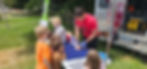Instructor showing child how to call 911 during a first aid workshop