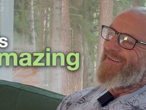 Denis smiling during a testimonial at a forest retreat, sharing his experience at Planet Kambo.