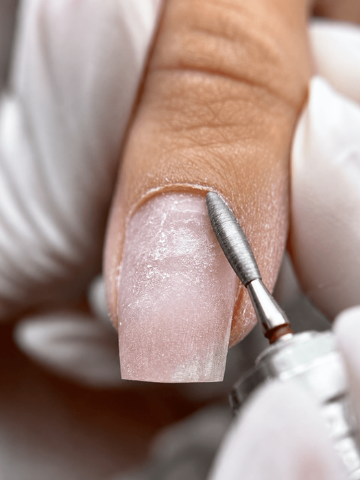 Close-up of a french manicure with a clean cuticle line and glossy finish