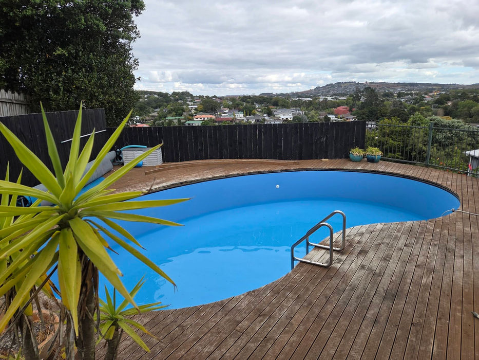 Kidney-shaped vinyl liner pool on elevated deck with hill views, Auckland
