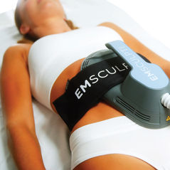 Woman undergoing Emsculpt Neo body contouring treatment on abdomen in a clinic setting