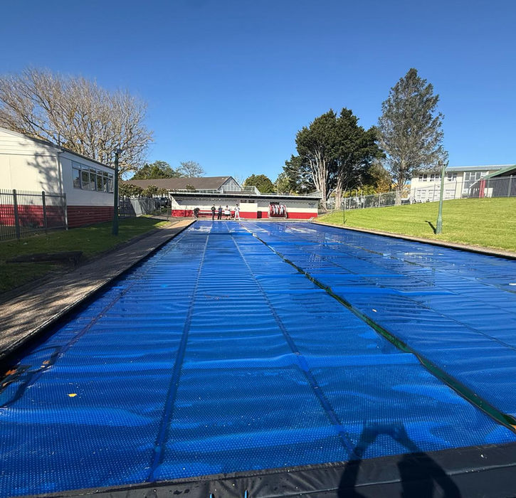 Full commercial solar bubble pool cover on school swimming pool, sunny day, installed by Aquatech Auckland New Zealand