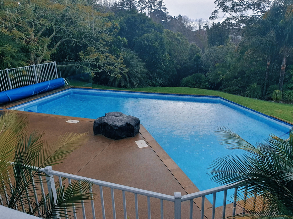 Pool liner replacement with rock water feature in rainy conditions, Auckland