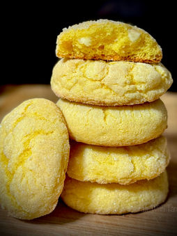 Soft lemon cheesecake cookies stacked on display