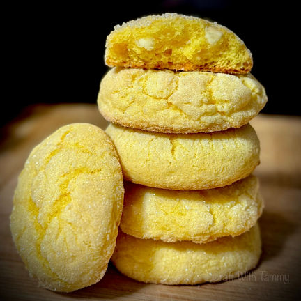 Soft lemon cheesecake cookies stacked on display
