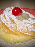 Traditional Italian Zeppole di San Giuseppe topped with custard and cherry