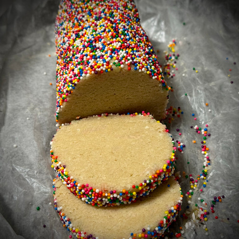 Sugar cookie dough log rolled in rainbow sprinkles sliced