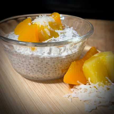 Chia seed pudding served in a jar with fruit, and coconut beside it