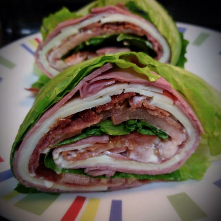 Lettuce-wrapped Unwich sandwich filled with turkey, roast beef, salami, tomato, and cheese.