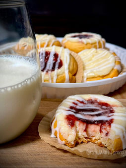Freshly baked cheese danishes with fruit filling and glaze