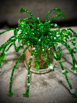 Beaded plant craft with handmade green leaves created from small glass beads and wire