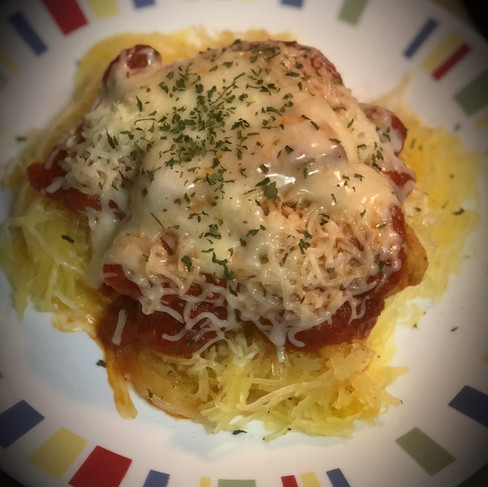 BFinished spaghetti squash dish garnished with parsley and cheese