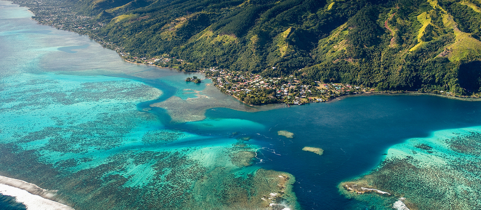 Aerial view of tropical islands and turquoise lagoons in the South Pacific.