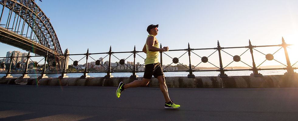 man in yellow tank top running near shor