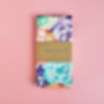 An image of a folded printed tea towel, with pastel-coloured floral print