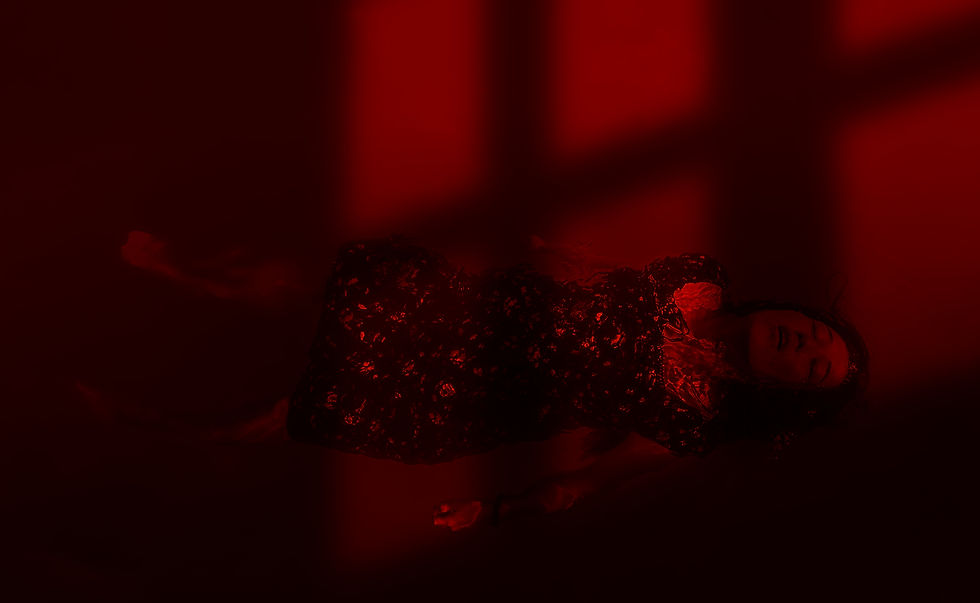 Image of a woman floating in red water.
