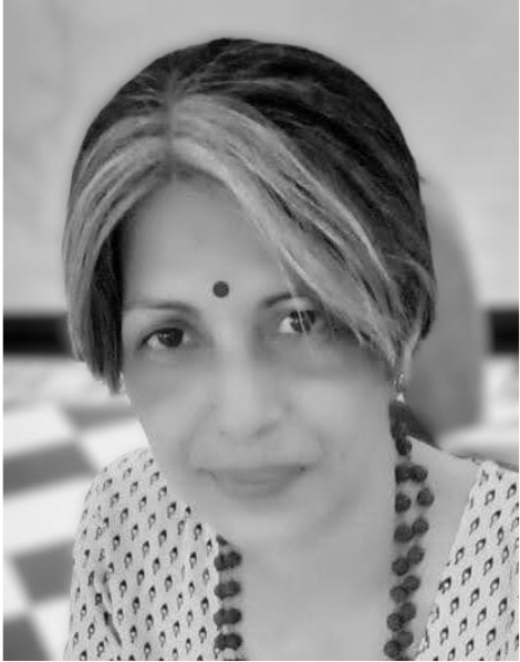 Black-and-white close-up portrait of a woman with a bindi and beaded necklace, looking calmly at the camera.