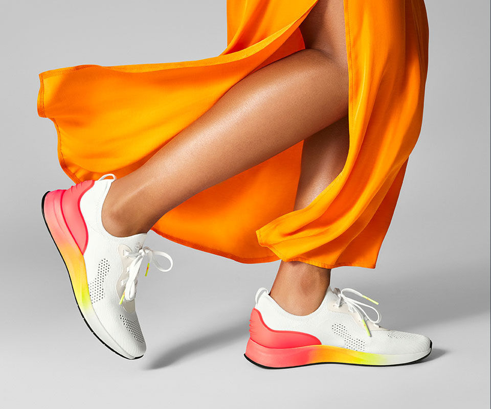 Detailaufnahme orangener Schuh an einem Model
