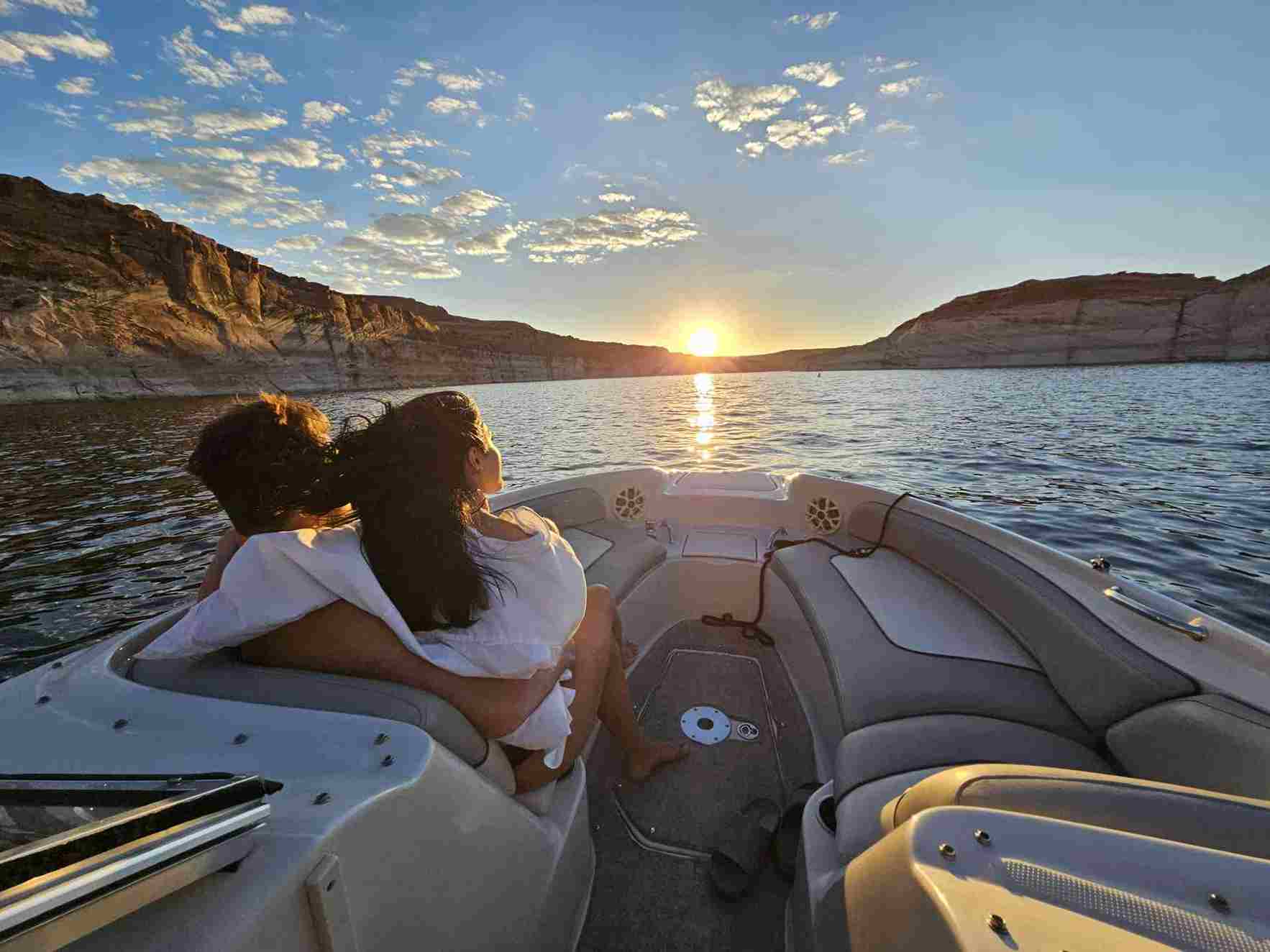A couple enjoys a romantic moment on a boat at sunset during a private photography tour.