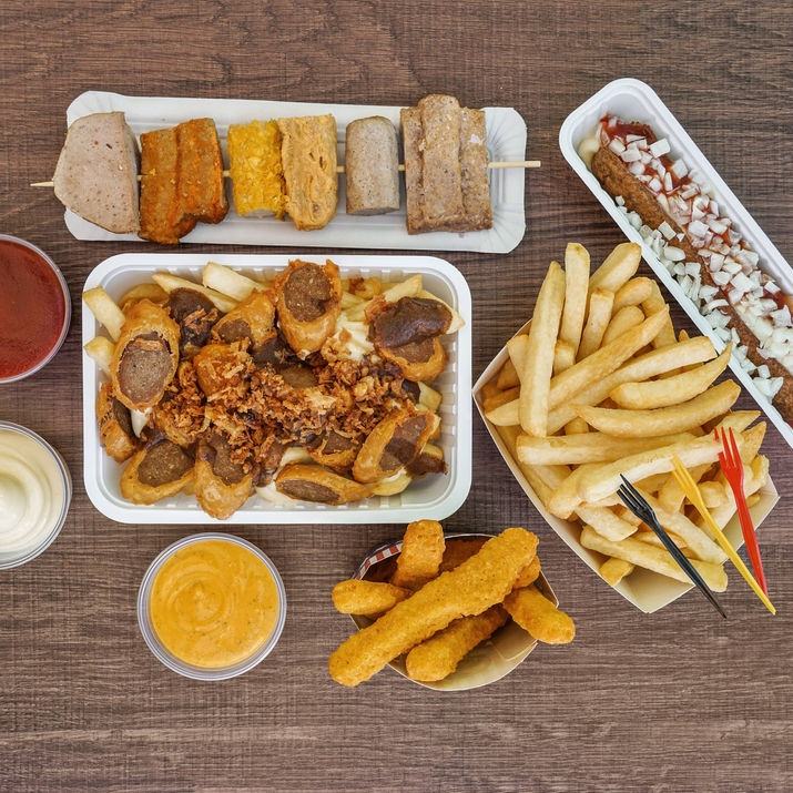 Tasty and delicious food prepared, found and served at Airna Frituur such as fries, Hotdogs, chicken wings, meats, sauces put on a table