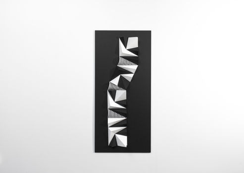 Pliage papier en relief présenté sous caisson plexiglas. Un volume géométrique en équilibre où l'ombre et la lumière recomposent la perception selon l'angle de vue.