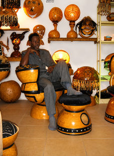 Visiteur assis sur un fauteuil en calebasse de Fabrice Beuillé alias Fabrice Ainaut au SIAO de Ouagadougou, Burkina Faso, 2002