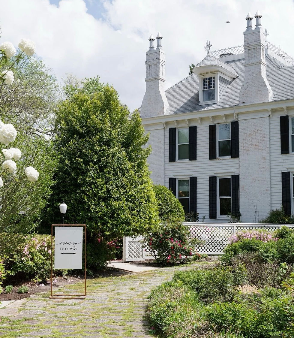 White mansion with black shutters, garden, and path