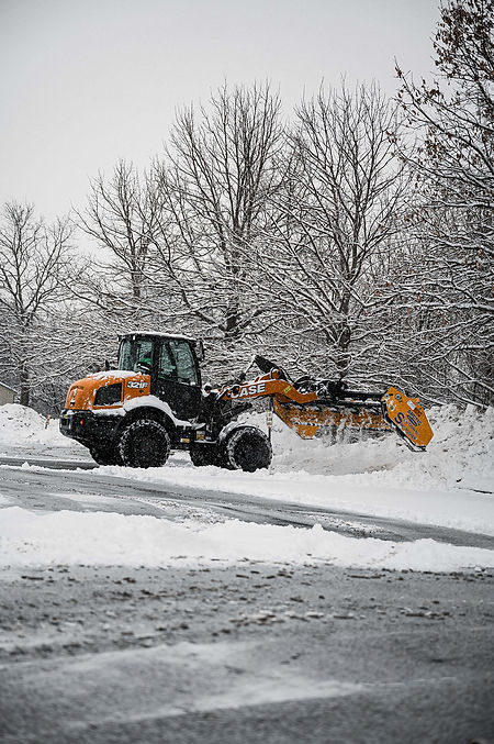 Case 321 plowing snow in a lot.